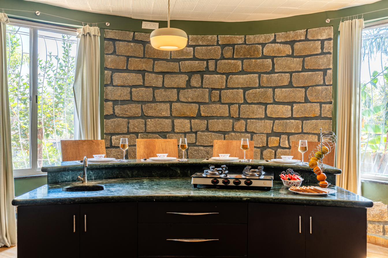 Curved dining nook with stone wall and green marble counter, suited to a small team breakfast or debrief