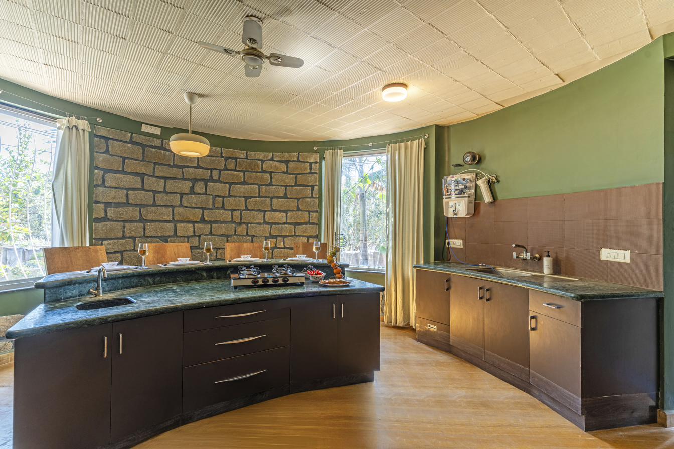 Full view of the curved kitchen showing both counters and dining seating