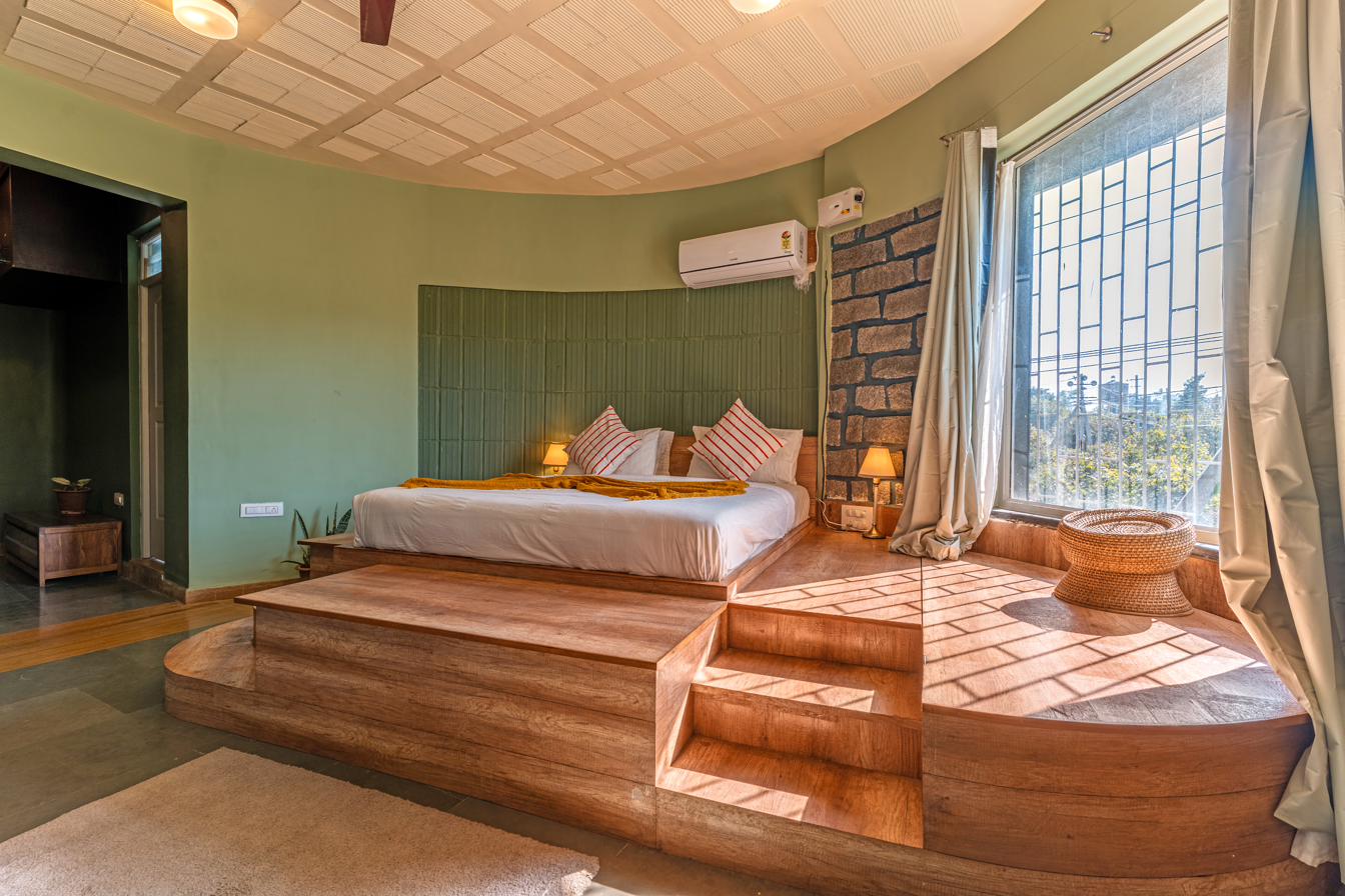 Raised circular platform bed with sage tile headboard and stone accent wall