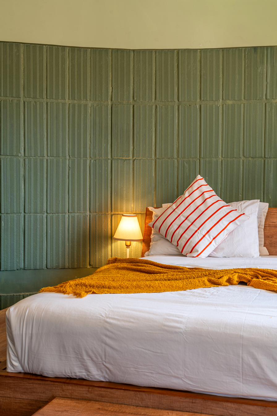 Close view of the sage tile ribbed headboard with striped and white cushions