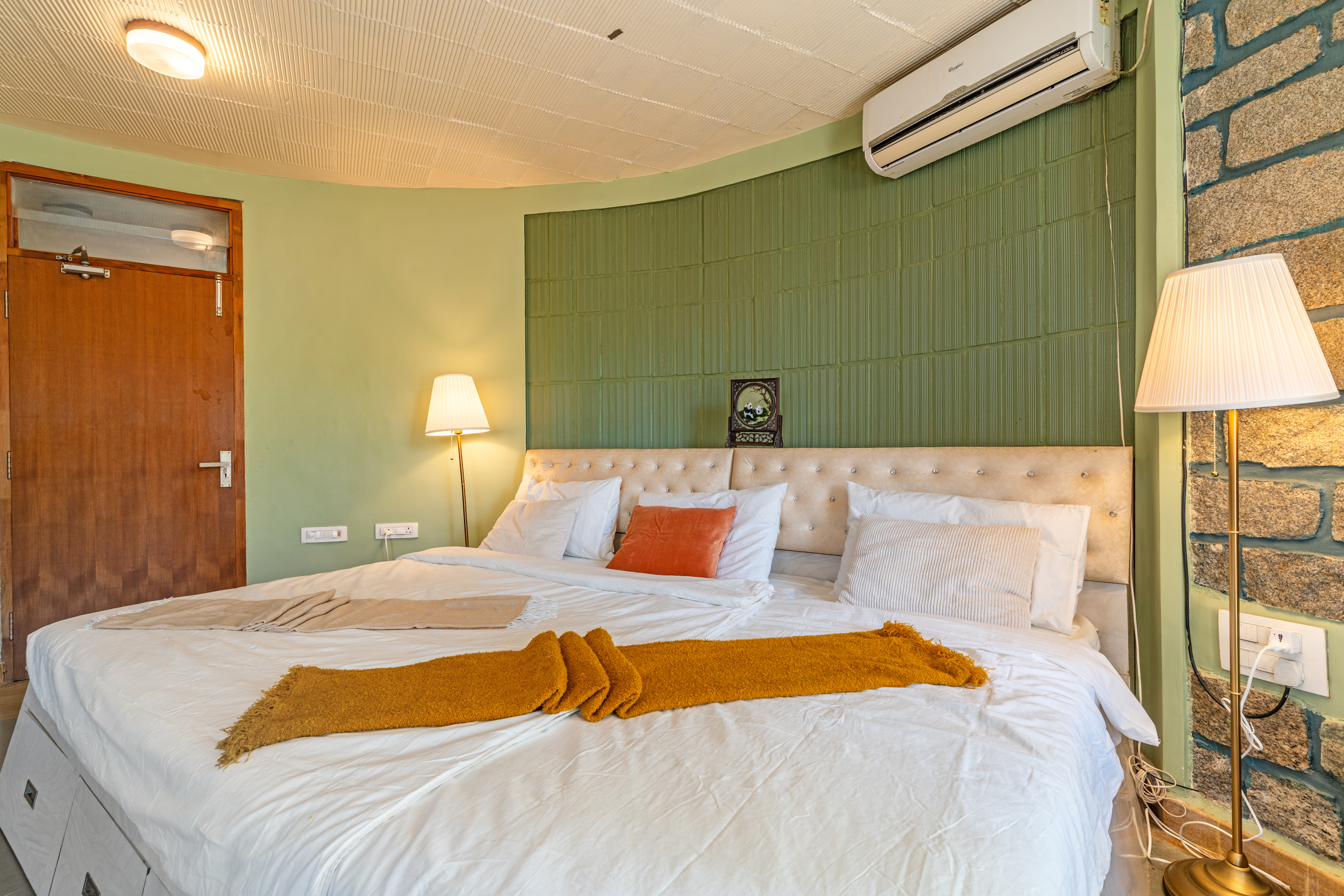 Sage Room with floor lamp, wooden door and stone accent wall