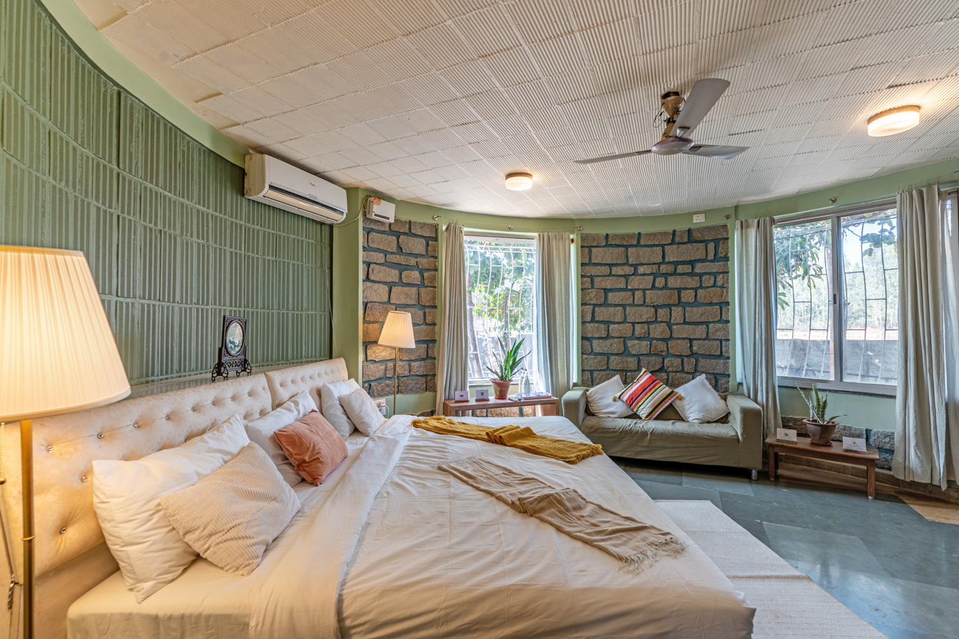Wide view of the Sage Room showing the sitting sofa, stone accent walls and garden-facing windows