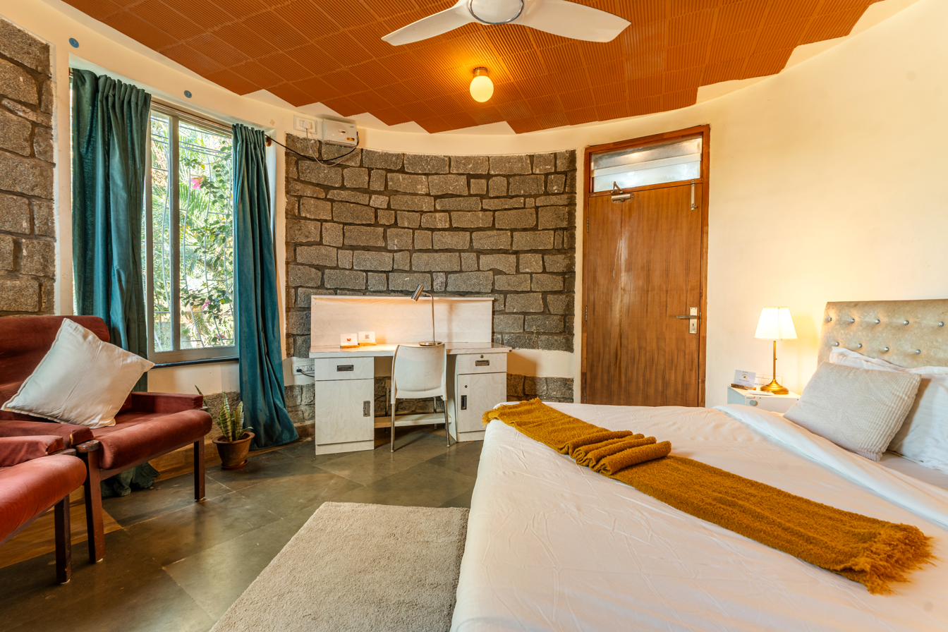 Curved stone wall with built-in work desk and reading lamp in the Stone and Teal Room