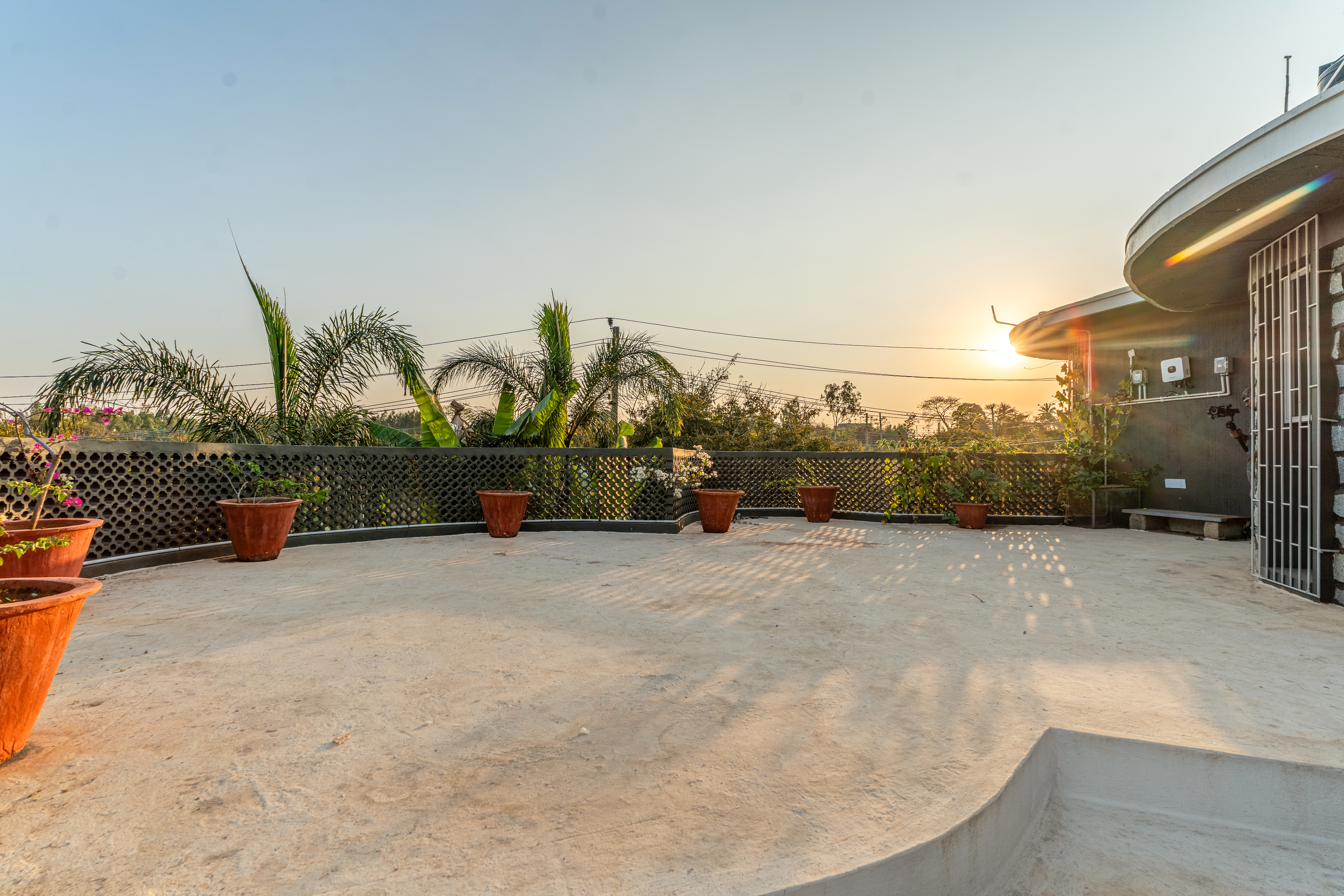 Rooftop terrace at golden hour with warm sun flare through the lattice parapet wall